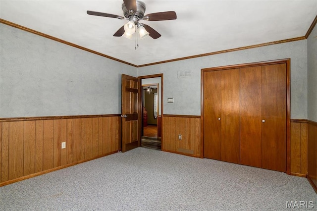 132 S Duncan St, Marine, IL 62061 - unfurnished bedroom with wainscoting, wooden walls, a closet, carpet flooring, and ceiling fan
