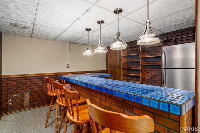 132 S Duncan St, Marine, IL 62061 - indoor dry bar with freestanding refrigerator, hanging light fixtures, brick wall, and carpet