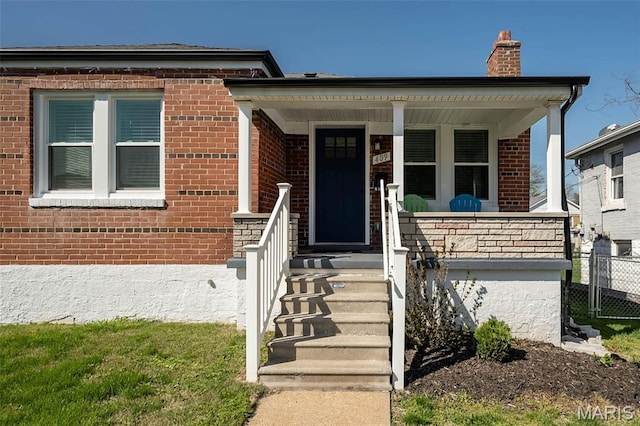 409 Jett Ave, Saint Louis, MO 63125 - view of front facade featuring brick siding, a chimney, fence, and a porch