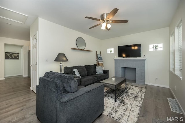 409 Jett Ave, Saint Louis, MO 63125 - living room with wood finished floors, ceiling fan, baseboards, and a fireplace