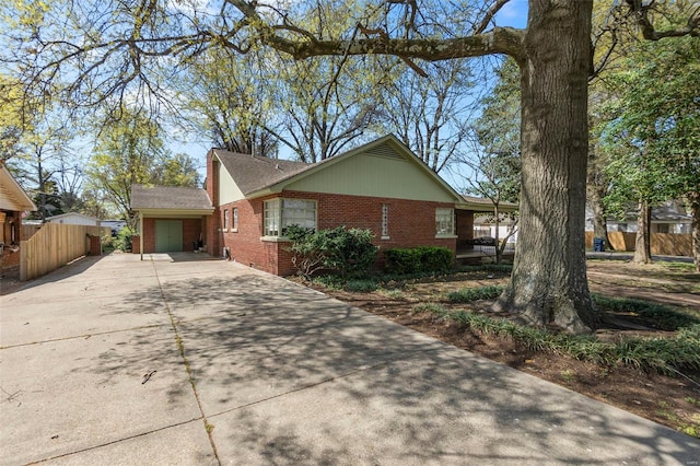 605 W Washington St, Kennett, MO 63857 - view of property exterior with concrete driveway, brick siding, and fence