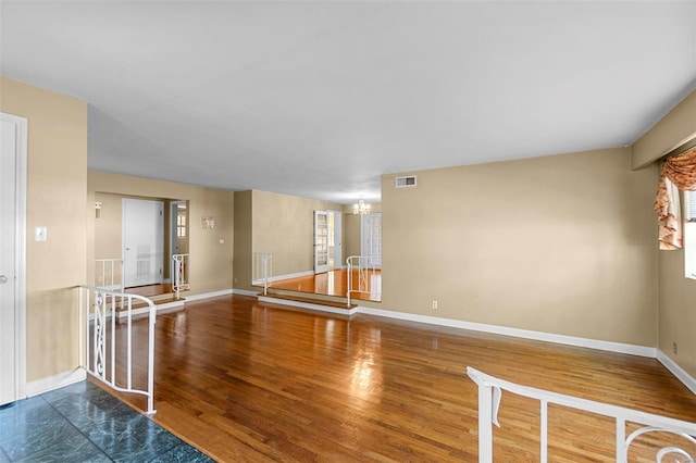 605 W Washington St, Kennett, MO 63857 - spare room featuring baseboards, a chandelier, and wood finished floors