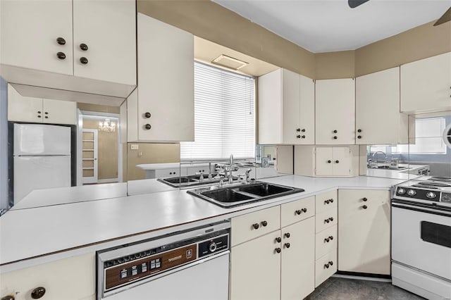 605 W Washington St, Kennett, MO 63857 - kitchen featuring white appliances, a sink, light countertops, and plenty of natural light