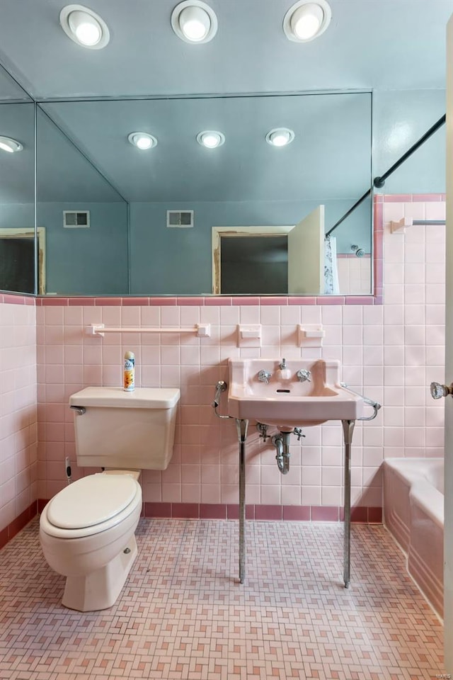 605 W Washington St, Kennett, MO 63857 - full bathroom featuring tile walls, toilet, a tub, tile patterned floors, and a shower