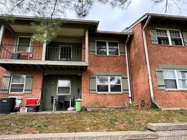 8736 Santa Bella Dr Unit G, Hazelwood, MO 63042 - view of front facade with a balcony, brick siding, and cooling unit