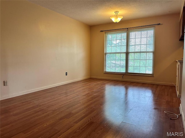 8736 Santa Bella Dr Unit G, Hazelwood, MO 63042 - empty room featuring dark wood finished floors, baseboards, and a textured ceiling