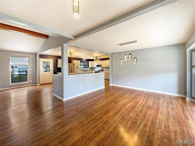 1 Pine Forest Ct, Dardenne Prairie, MO 63368 - unfurnished living room featuring dark wood-style floors, baseboards, and a textured ceiling