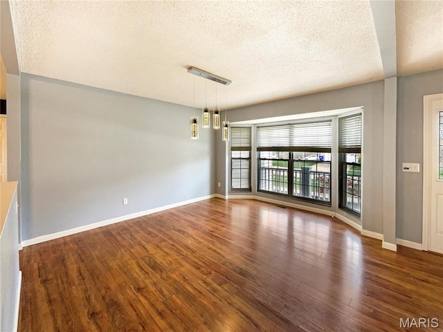 1 Pine Forest Ct, Dardenne Prairie, MO 63368 - unfurnished room featuring a textured ceiling, wood finished floors, and baseboards