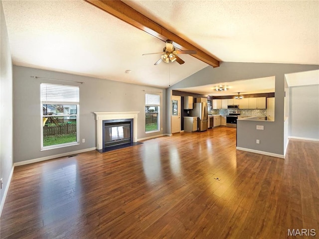 1 Pine Forest Ct, Dardenne Prairie, MO 63368 - unfurnished living room with dark wood-style flooring, plenty of natural light, ceiling fan, a glass covered fireplace, and a textured ceiling