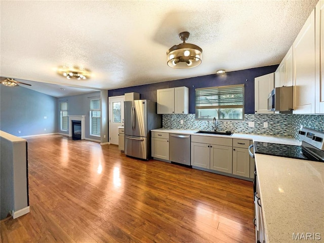 1 Pine Forest Ct, Dardenne Prairie, MO 63368 - kitchen with appliances with stainless steel finishes, a sink, a textured ceiling, decorative backsplash, and light countertops