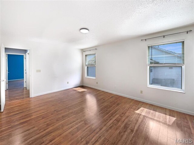 1 Pine Forest Ct, Dardenne Prairie, MO 63368 - spare room with a textured ceiling, wood finished floors, plenty of natural light, and baseboards