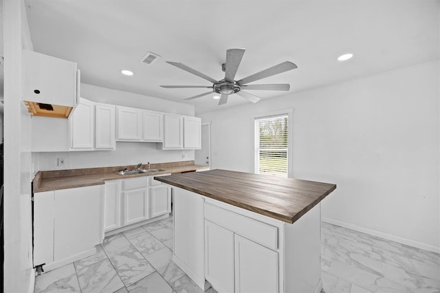 47 E Adams Dr E, St Louis, IL 62206 - kitchen featuring wooden counters, light marble finish floors, a sink, white cabinetry, and ceiling fan