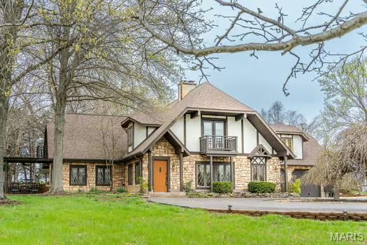 762 Crider Ln, Union, MO 63084 - tudor-style house featuring a balcony, stone siding, stucco siding, and a front lawn