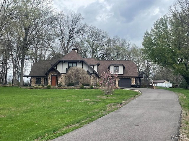 762 Crider Ln, Union, MO 63084 - tudor-style house featuring stone siding, asphalt driveway, a front yard, and an attached garage