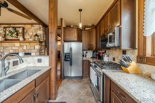 762 Crider Ln, Union, MO 63084 - kitchen with stainless steel appliances, a sink, tasteful backsplash, brown cabinetry, and light stone countertops