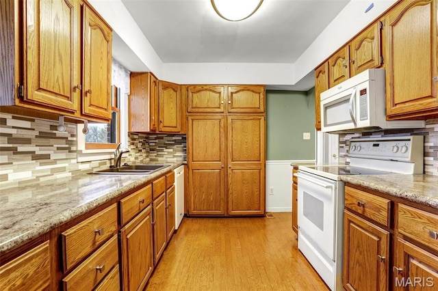 765 Pottery Tower Ln, Washington, MO 63090 - kitchen with white appliances, a sink, brown cabinets, light wood-type flooring, and light stone counters