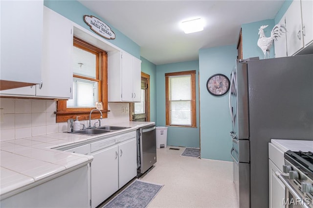 110 W Scioto St, St James, MO 65559 - kitchen featuring appliances with stainless steel finishes, tile countertops, white cabinets, and decorative backsplash