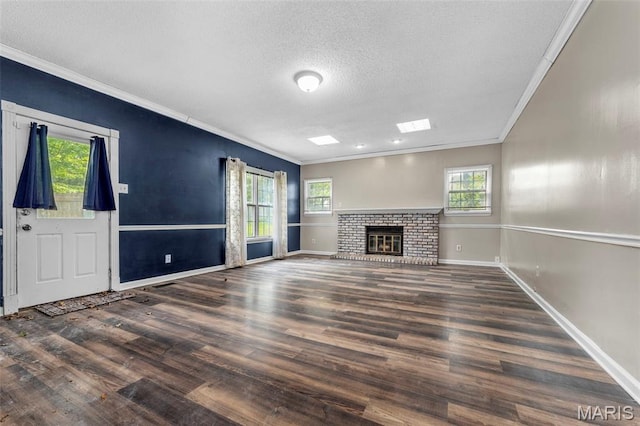 1064 Pinecone Trl, Florissant, MO 63031 - unfurnished living room featuring crown molding, a textured ceiling, baseboards, plenty of natural light, and wood finished floors
