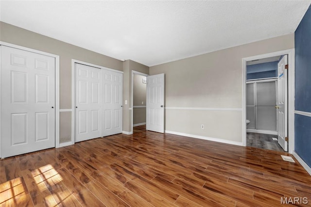 1064 Pinecone Trl, Florissant, MO 63031 - unfurnished bedroom featuring wood finished floors, baseboards, and connected bathroom