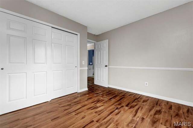 1064 Pinecone Trl, Florissant, MO 63031 - unfurnished bedroom featuring wood finished floors, baseboards, and a closet