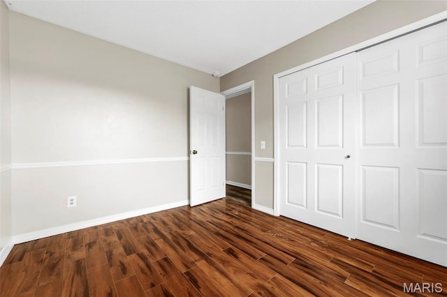1064 Pinecone Trl, Florissant, MO 63031 - unfurnished bedroom with dark wood-style flooring, baseboards, and a closet