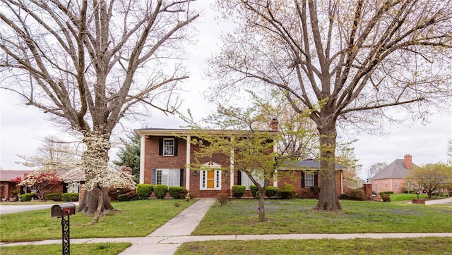 112 Summer Dr, Sikeston, MO 63801 - greek revival inspired property featuring brick siding, a front yard, and a chimney