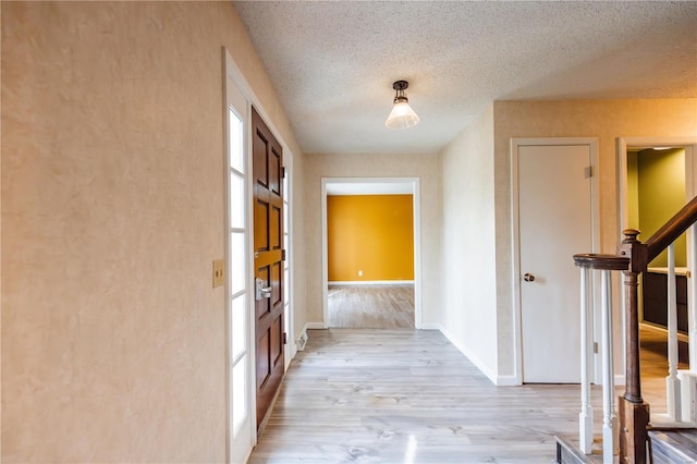 112 Summer Dr, Sikeston, MO 63801 - hall with light wood-style floors, stairway, a textured ceiling, and baseboards