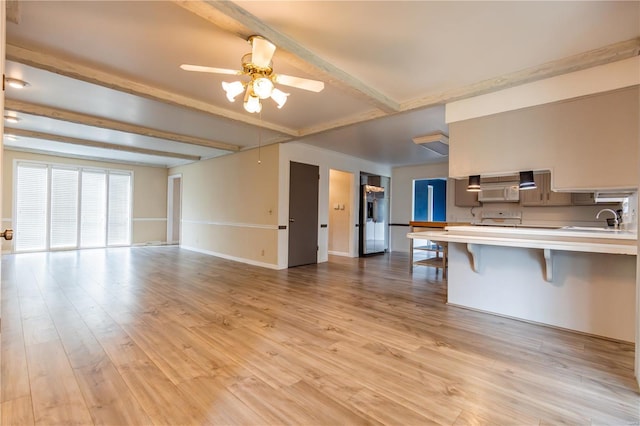 112 Summer Dr, Sikeston, MO 63801 - unfurnished living room with a sink, beam ceiling, a ceiling fan, light wood-style flooring, and baseboards