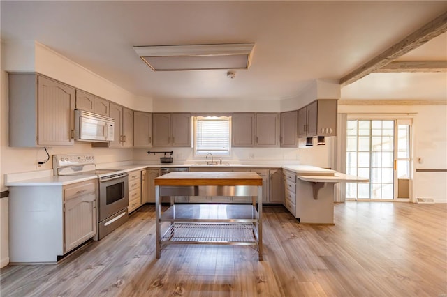 112 Summer Dr, Sikeston, MO 63801 - kitchen with electric range, white microwave, light countertops, a sink, and light wood-style floors