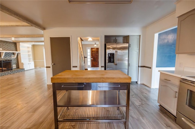 112 Summer Dr, Sikeston, MO 63801 - kitchen with stainless steel refrigerator with ice dispenser, wood counters, range with electric cooktop, light wood-style flooring, and a brick fireplace