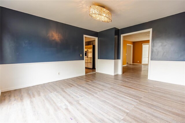 112 Summer Dr, Sikeston, MO 63801 - spare room with wood finished floors, a chandelier, and baseboards