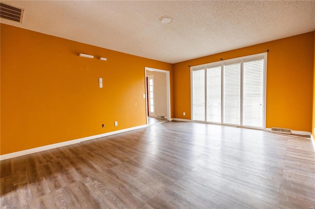 112 Summer Dr, Sikeston, MO 63801 - empty room with a textured ceiling, wood finished floors, and baseboards