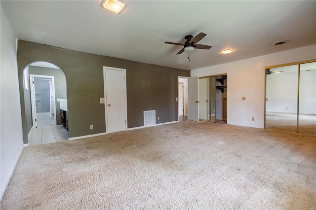 112 Summer Dr, Sikeston, MO 63801 - unfurnished bedroom featuring two closets, light colored carpet, arched walkways, baseboards, and ensuite bathroom