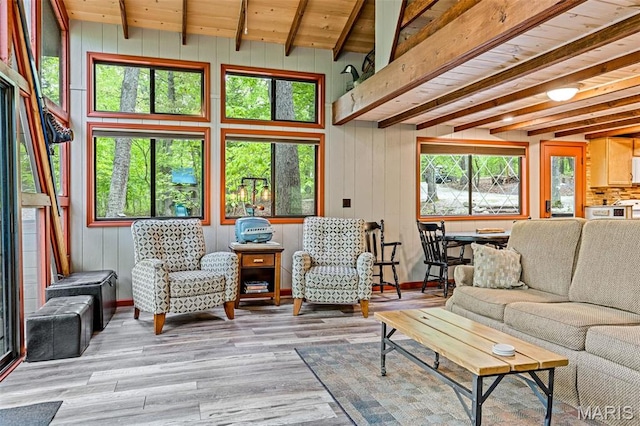 living room featuring beam ceiling, wood finished floors, wooden ceiling, wood walls, and baseboards