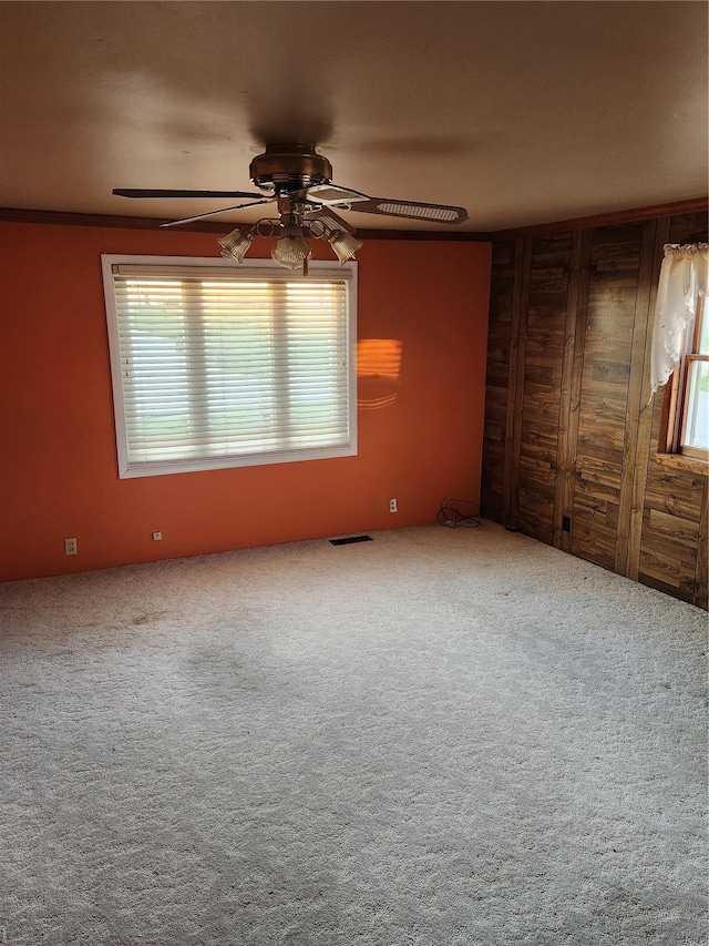 carpeted spare room featuring a ceiling fan and plenty of natural light