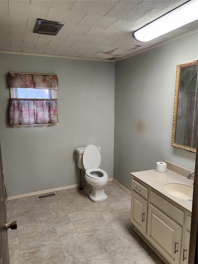 bathroom featuring toilet, vanity, baseboards, and tile patterned floors