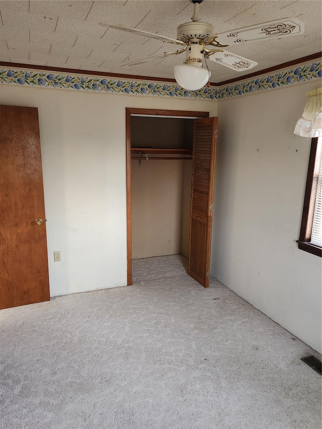 unfurnished bedroom with light carpet, a closet, and ceiling fan