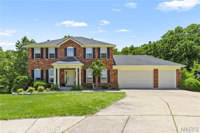 16112 Ridgewoods Manor Cir, Ellisville, MO 63038 - colonial home with a garage, driveway, a front yard, and brick siding