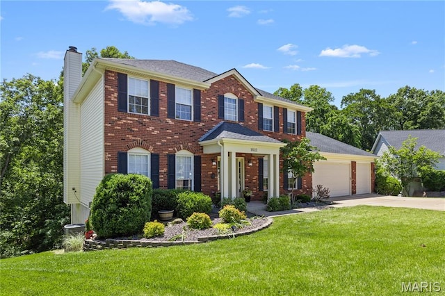 16112 Ridgewoods Manor Cir, Ellisville, MO 63038 - colonial-style house with a chimney, concrete driveway, a garage, a front yard, and brick siding