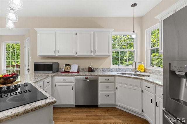 16112 Ridgewoods Manor Cir, Ellisville, MO 63038 - kitchen featuring stainless steel appliances, a sink, white cabinets, hanging light fixtures, and light wood-style flooring