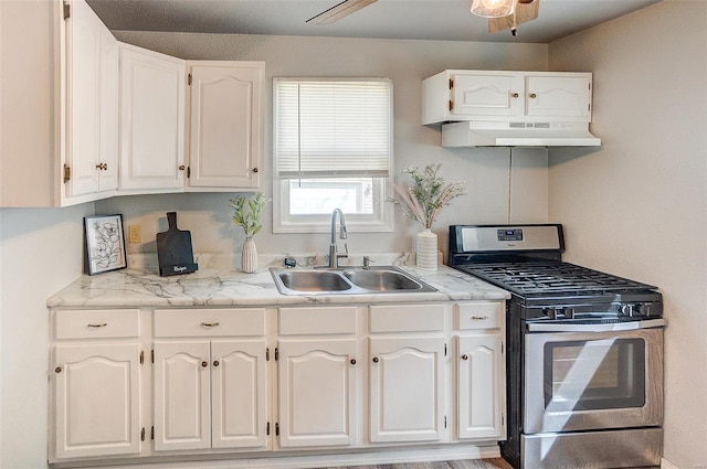 1810 N Van Buren St, Litchfield, IL 62056 - kitchen with gas range, a sink, under cabinet range hood, and white cabinetry