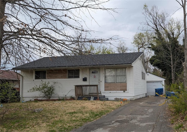 213 Grampian Rd, Saint Louis, MO 63137 - view of front facade featuring a garage, a shingled roof, a front yard, and an outdoor structure
