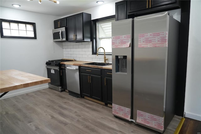 9235 Catalina Dr, Saint Louis, MO 63136 - kitchen featuring appliances with stainless steel finishes, a sink, plenty of natural light, and wooden counters