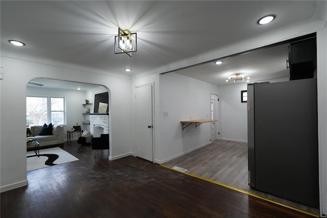 9235 Catalina Dr, Saint Louis, MO 63136 - interior space featuring arched walkways, wood finished floors, a fireplace, baseboards, and recessed lighting