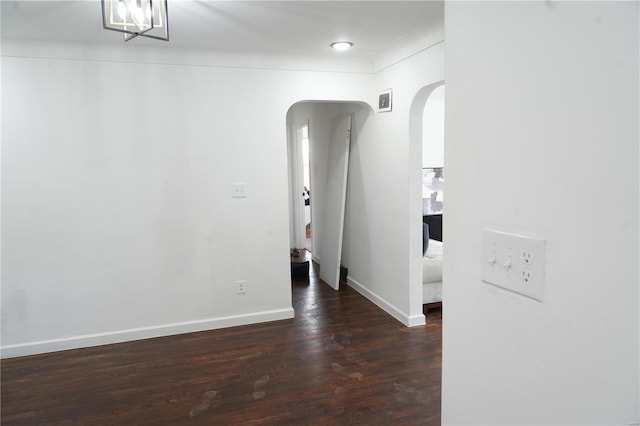 9235 Catalina Dr, Saint Louis, MO 63136 - empty room with arched walkways, wood finished floors, and baseboards