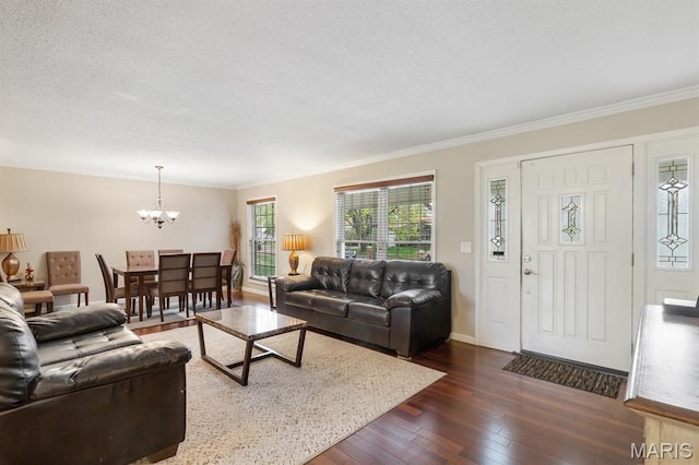 269 Braeshire Dr, Ballwin, MO 63021 - living room featuring a chandelier, dark wood-style flooring, a textured ceiling, crown molding, and baseboards