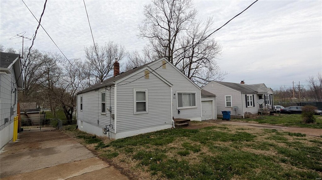 6349 Garfield Ave, Saint Louis, MO 63134 - view of property exterior featuring a chimney, a garage, and fence