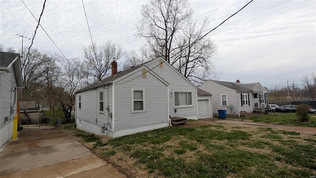 6349 Garfield Ave, Saint Louis, MO 63134 - view of property exterior featuring a chimney, a garage, and fence