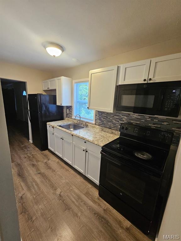 7200 Sapphire Ave, Saint Louis, MO 63136 - kitchen featuring black appliances, white cabinets, dark wood finished floors, decorative backsplash, and light stone counters