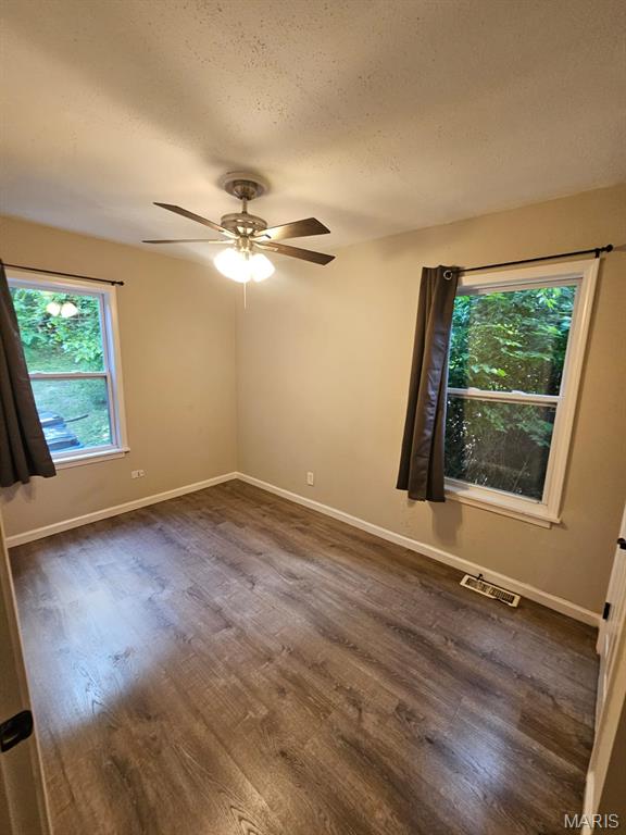 7200 Sapphire Ave, Saint Louis, MO 63136 - unfurnished room featuring dark wood-style floors, ceiling fan, and a textured ceiling
